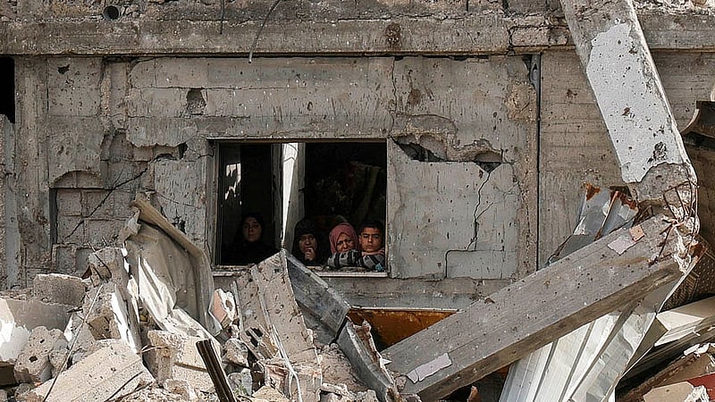 Palestinians look on as a crowd (not pictured) inspects the site of an Israeli strike on a house, in Khan Younis in the southern Gaza Strip April 6, 2025. Photo: Reuters