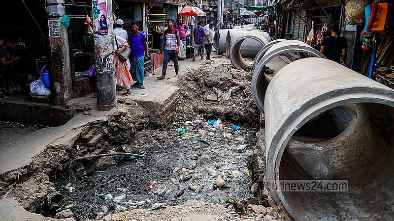 A big hole has been dug on the road, and a large concrete pipe is kept next to it, making it hard to walk. People in Dhaka's Dayaganj Bazar have been struggling with this for days. Photo: Mahmud Zaman Ovi