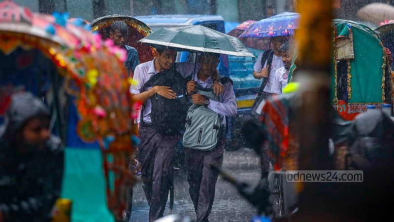 Two students share an umbrella as they walk through the rain at Mohammadpur bus stand in Dhaka on Monday, Jul 1, 2024. Photo: Mahmud Zaman Ovi