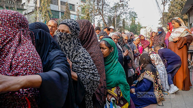 People queue to buy products from Trading Corporation of Bangladesh (TCB) trucks in the blazing sun on Wednesday, Feb 18, 2026, near the Town Hall in Dhaka’s Mohammadpur. Photo: Mahmud Zaman Ovi