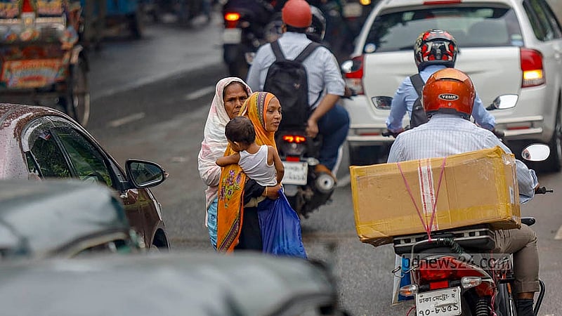 A little awareness can greatly reduce risk. Despite a footbridge being right overhead, a woman is seen crossing the busy road with a baby in her arms instead of using it on Monday, Jul 7, 2025. Photo: Mahmud Zaman Ovi