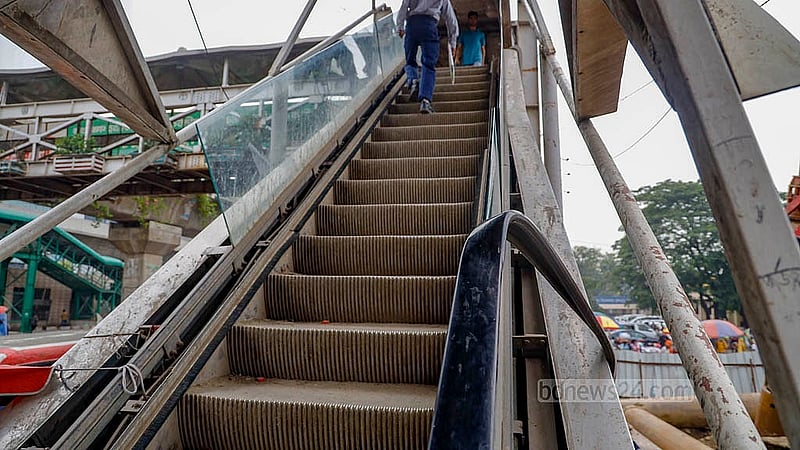 The handrail rubber on one side of the escalator of the footover bridge at Dhaka's airport road has been removed, while it hangs on the other side on Monday, May 5, 2025. Photo: Mahmud Zaman Ovi