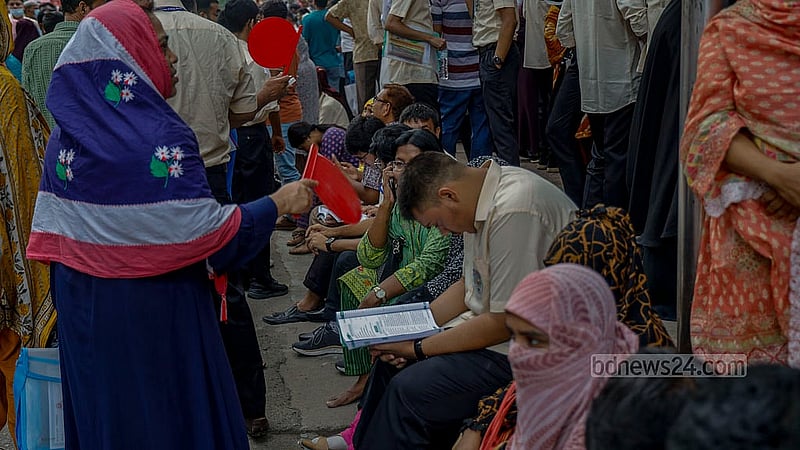 Amid the scorching heat in the Bengali month of Ashar, a guardian cools a student with a handmade fan outside the Siddeshwari Girls’ College centre in Dhaka, before the start of the HSC exams on Thursday, Jun 26, 2025. Photo: Mahmud Zaman Ovi
