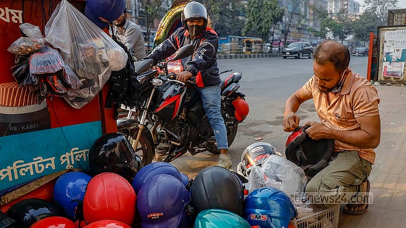 A temporary helmet shop run by Bachchu Mia on the footpath at the Science Lab intersection sells helmets and offers repairs for locks and visors. Photo: Mahmud Zaman Ovi
