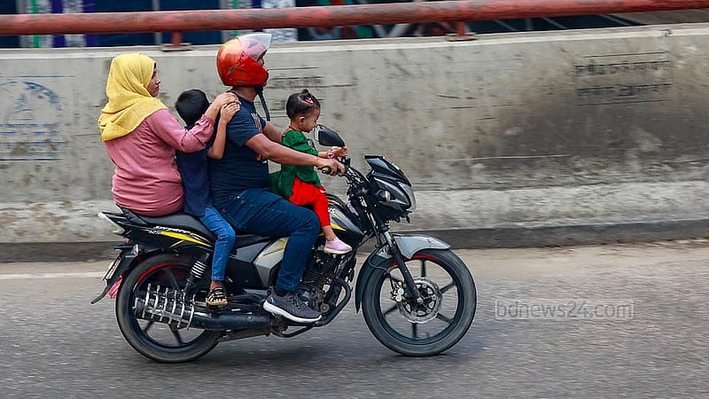 Four people, including two children, are on a motorcycle on the busy Moghbazar-Mouchak flyover in Dhaka. Aside from the rider, none of them are wearing helmets. Photo: Mahmud Zaman Ovi