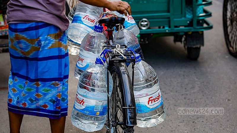 A man transports water containers on his bicycle after collecting them from a water ATM booth in Dhaka’s Banasree. Photo: Mahmud Zaman Ovi