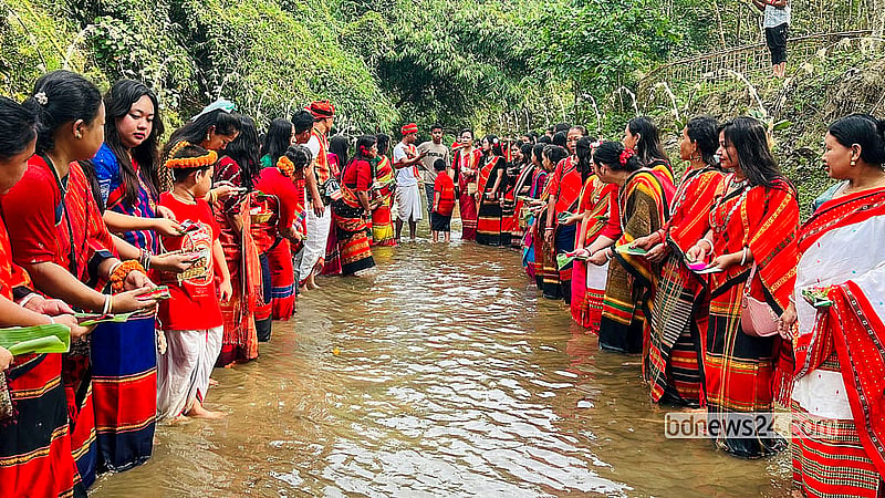 People of the Tripura community float different flowers, including Rangoon Creeper, Yellow Bell, and Hibiscus, and new hand-woven clothes in Khagrachhari's Chengi River for Goddess Ganga on Hari Boisu. Photo: Samir Mallik