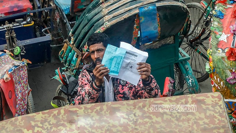 A rickshaw driver displays his release slip at the dumping station on the northern side of the Postogola Bridge. Photo: Abdullah Al Momin
