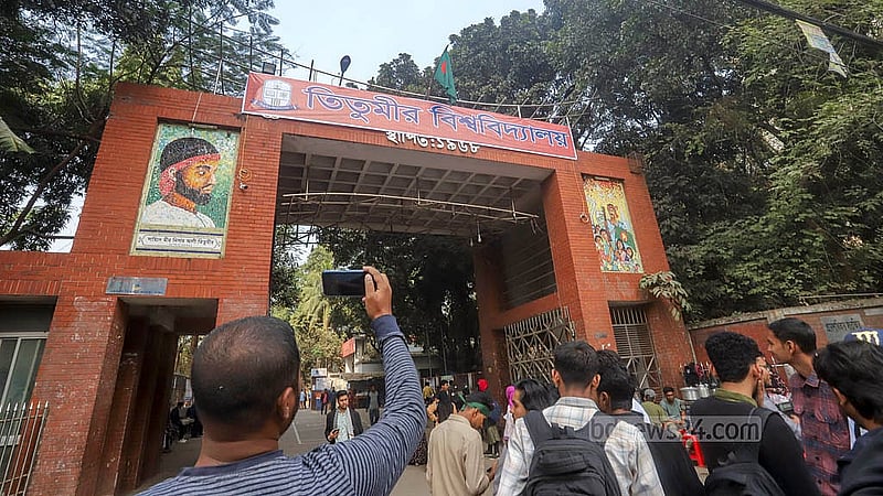 Students cheer after hanging banner with the name “Titumir University” over the main gate, covering the name of Titumir College.  Photo: Abdullah al Momin