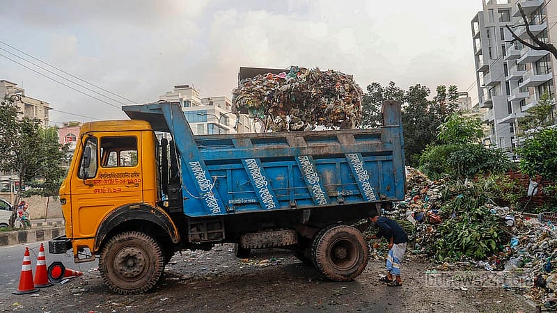 Waste dumped on Pragati Sarani is being loaded onto a DNCC truck with an excavator. Photo: Mahmud Zaman Ovi