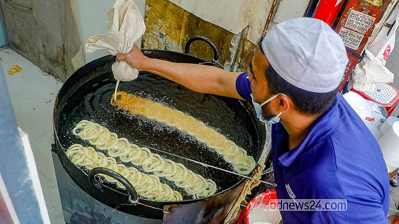 Jilapi is being prepared as a popular Iftar item on Bailey Road. Customers crowd around to buy the hot sweets. Ghee-fried Jilapi is selling at Tk 550 per kg. Photo: Abdullah Al Momin