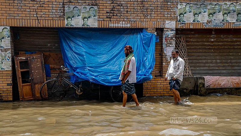 Pedestrians wade through knee-deep water as a road in Mirpur, Dhaka, submerged due to heavy rain on Sunday, Aug 17, 2025. Photo: Mahmud Zaman Ovi