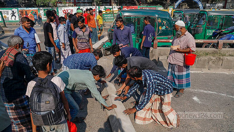 Drivers of battery-run rickshaws protest by blocking the road with a slab of a railway line in Dhaka’s Khilgaon on Thursday, Nov 21, 2024.