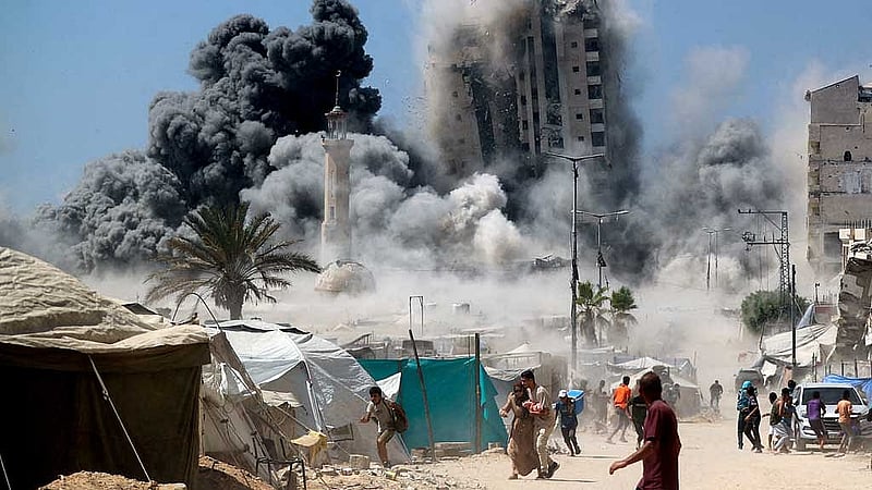 Palestinians run as the 15-storey Mushtaha Tower collapses after being hit by an Israeli air strike, in Gaza City, September 5, 2025. REUTERS