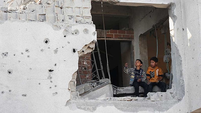 Palestinian boys sit at the site of an Israeli strike on a house, in Jabalia, northern Gaza Strip May 21, 2025. REUTERS