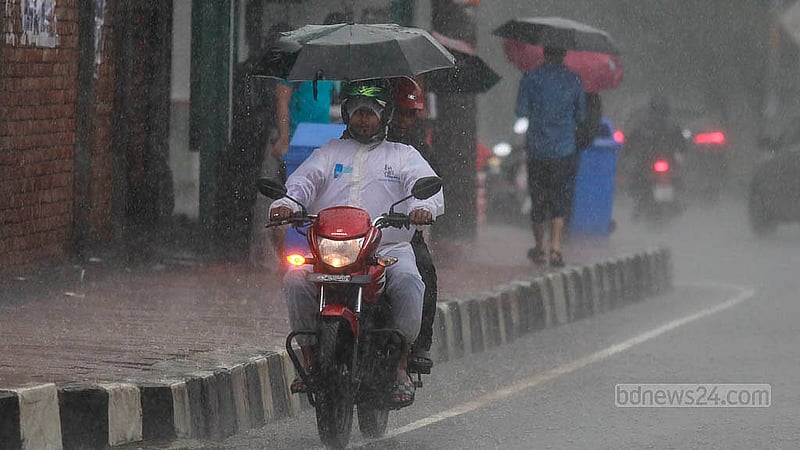 A man driving a motorcycle amid a heavy rain in Dhaka’s Hatirjheel with a pillion rider carrying an umbrella on Thursday, Sept 26, 2024.Photo: Mahmud Zaman Ovi