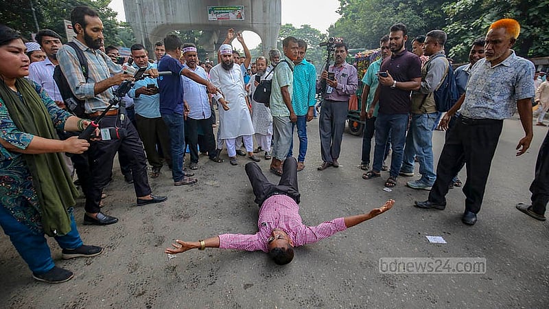 An MPO-listed teacher lies on the road after police moved in to disperse the demonstrators demanding higher house rent allowances in front of the National Press Club on Sunday, Oct 12, 2025.