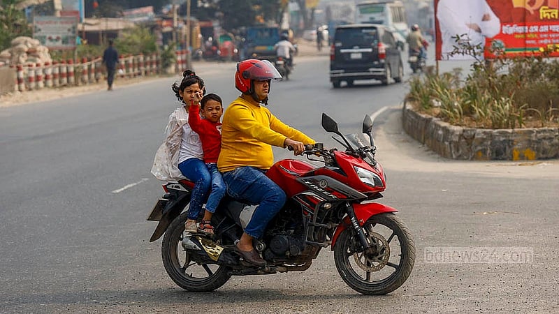 A motorcyclist carrying two children on the back crosses the highway at Matuail to make a U-turn amid moving traffic. Photo: Mahmud Zaman Ovi
