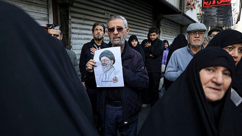 A man holds an image of late Iranian Supreme Leader Ayatollah Ali Khamenei as people attend a funeral ceremony for the Iranian military commanders who were killed in strikes, amid the U.S.-Israeli conflict with Iran, in Tehran, Iran, March 11, 2026. Photo: Reuters