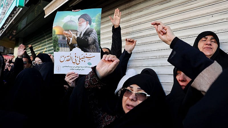 woman holds a poster with the picture of Iran's Supreme Leader Ayatollah Ali Khamenei as people gather after Khamenei was killed in Israeli and U.S. Photo: ReutersPhoto: Reutersstrikes on Saturday, in Tehran, Iran, March 1, 2026.