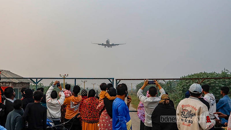 Crowds wait along the barbed-wire fence near the runway at Dhaka's Hazrat Shahjalal International Airport, hoping to catch a close-up view of the planes. Photo: Mahmud Zaman Ovi