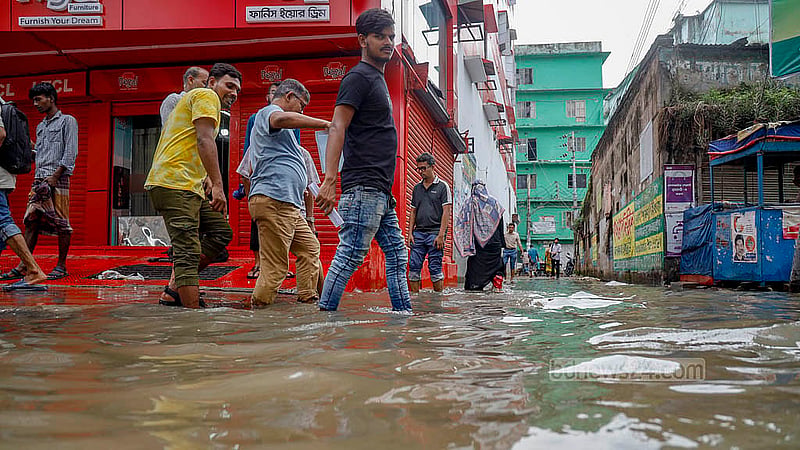 Pedestrians wade through knee-deep water as a road in Mirpur, Dhaka, submerged due to heavy rain on Sunday, Aug 17, 2025. Photo: Mahmud Zaman Ovi