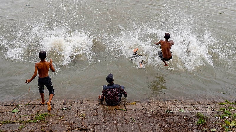 Children play in the Buriganga River as the monsoon rain freshens up the pitch dark water. Photo: Mahmud Zaman Ovi
