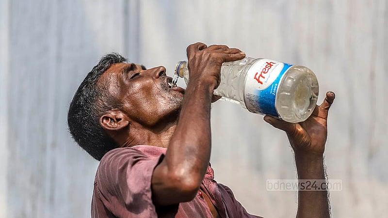 Day labourers suffer the most in the scorching heat. Rickshaw pullers fill up their bottles from a tap in front of Bangabhaban Colony in Tikatuli to quench their thirst on Sunday, Apr 6, 2025.  Photo: Abdullah al Momin