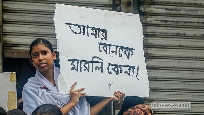 A student holds a placard demanding justice and action against Bright School Founding Chairman Masud Hasan Liton during the demonstration on Thursday, May 21, 2026.  Photo: Abdullah Al Momin