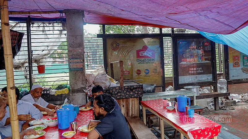A Dhaka North City Corporation passenger shed has been set yo on the footpath in front of Shaheed Suhrawardy Medical College. However, people sit under the shed to wait for their food instead of buses as a wayside restaurant has been set up inside. Photo: Mahmud Zaman Ovi