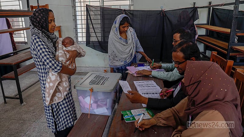 A voter arrives at a booth at Banani Model High School with her child in her arms on Thursday, Feb 12, 2026. Photo: Mahmud Zaman Ovi