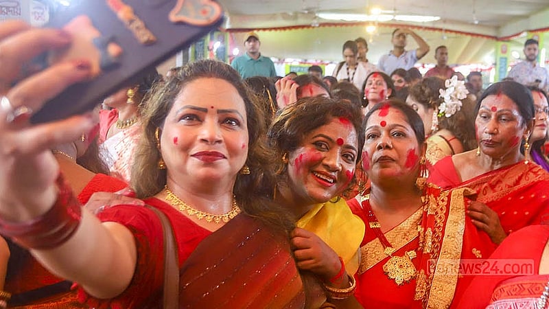 People take pictures while partaking in ‘Sindur Khela’ before the immersion of the idol of Goddess Durga at Dhakeshwari Temple on Sunday, Oct 13, 2024. Photo: Abdullah al Momin