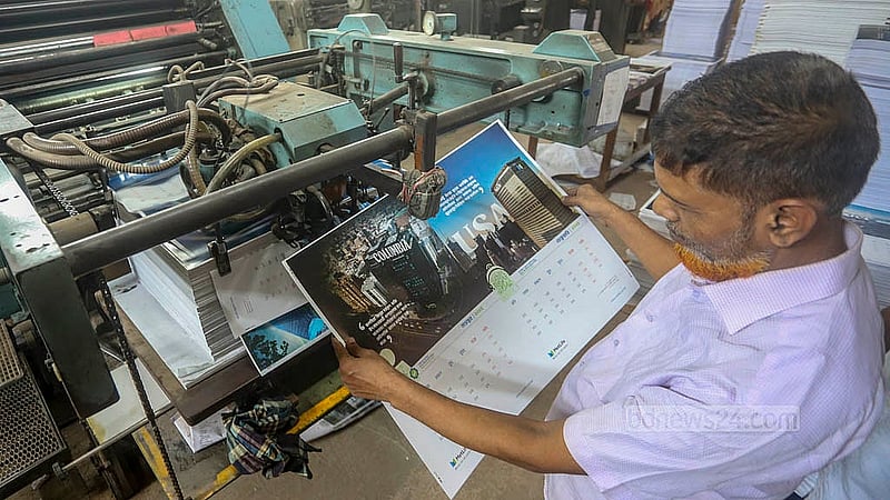 A man checking the prints of the calendar pages. The picture was taken at a printing house in Dhaka's Matuail on Tuesday, Nov 12, 2024. Photo: Abdullah al Momin