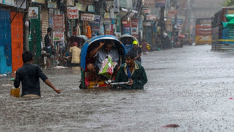 A driver tries to navigate a rickshaw through the waist-high water at Dhaka’s Sayedabad after a day of heavy rain brought on by Cyclone Remal causes waterlogging. Photo: Muhammad Mostafigur Rahman