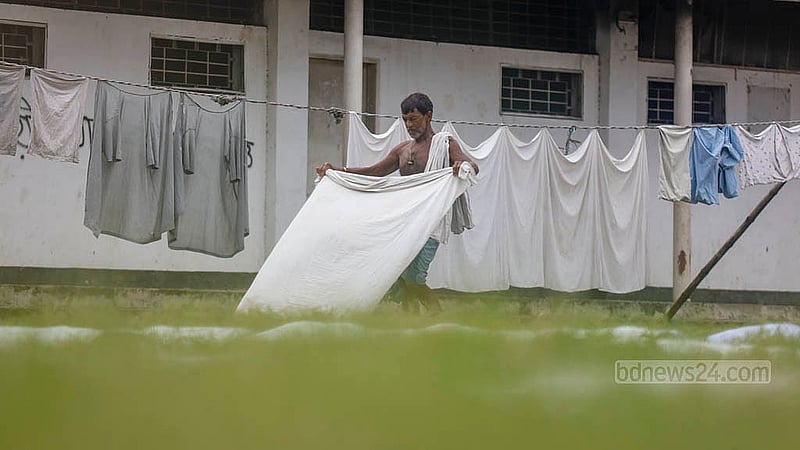 Washed decoration clothes have been spread out on the grass in the Alia madrasa field in Old Dhaka’s Bakshibazar. The long grass indicates how infrequently people now visit the area. Photo: Mahmud Zaman Ovi