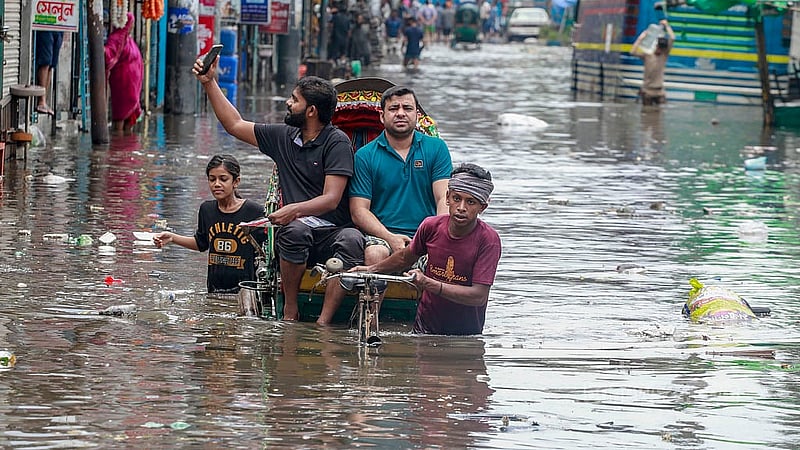 A man takes a selfie on his mobile while crossing the waterlogged road near the Syedabad Bus Stand in Dhaka on a rickshaw on Tuesday, May 28, 2024. Photo: Muhammad Mostafigur Rahman