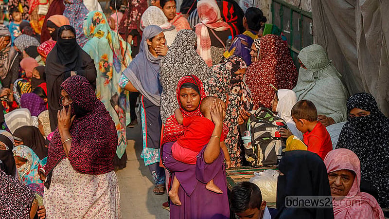 A woman stands in line with a baby in her arms to buy goods from a Trading Corporation of Bangladesh (TCB) truck near Mohammadpur’s Town Hall on Wednesday, Feb 18, 2026. Photo: Mahmud Zaman Ovi