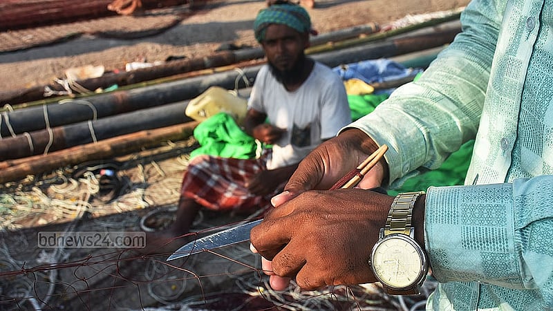 Fishermen repair nets in Chattogram’s Fisheryghat area during a ban on marine fishing. Photo: Suman Babu