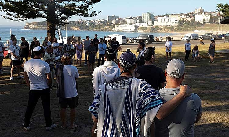 Members of the Jewish community gather for Shacharit, morning prayers, as the crime scene was reopened following the mass shooting at Bondi Beach on Sunday, in Sydney, Australia, Dec 19, 2025. REUTERS/Hollie Adams