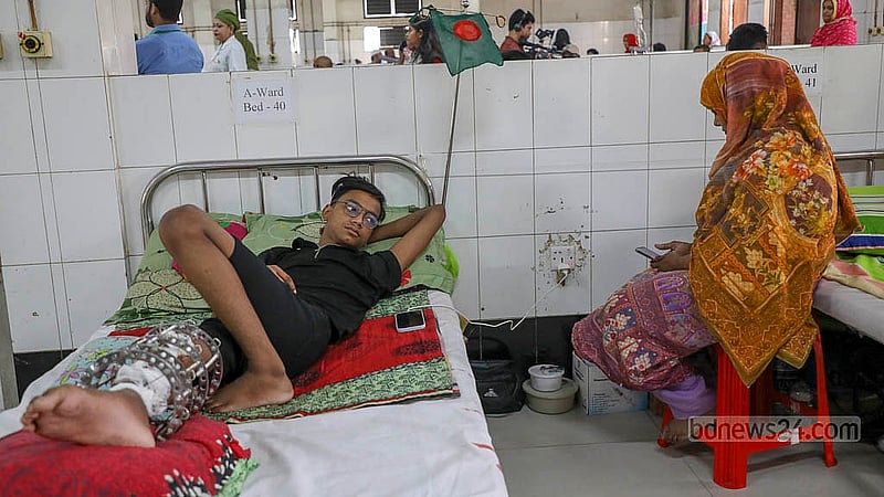 One injured individual lies on a hospital bed at the National Institute of Traumatology and Orthopaedic Rehabilitation, or NITOR, with relatives seated beside him. Photo: Mahmud Zaman Ovi
