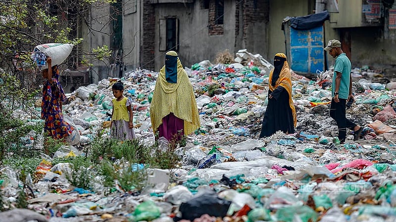 People are walking over the Shubhadda Canal, where the waste has built up over time. The layer of plastic waste is thick enough for people to walk over it. Photo: Mahmud Zaman Ovi