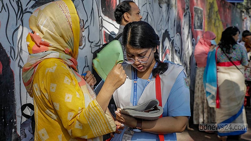 A student glances through her notes one last time outside the exam centre, her mother standing close by on Thursday, Apr 10, 2025. Photo: Mahmud Zaman Ovi