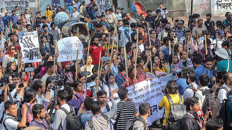 Dhaka University teachers and students, under the banner of the “Bangladesh Against Rape and Repression” platform, holding a baton march from the foot of Raju Sculpture. Photo: Abdullah al Momin