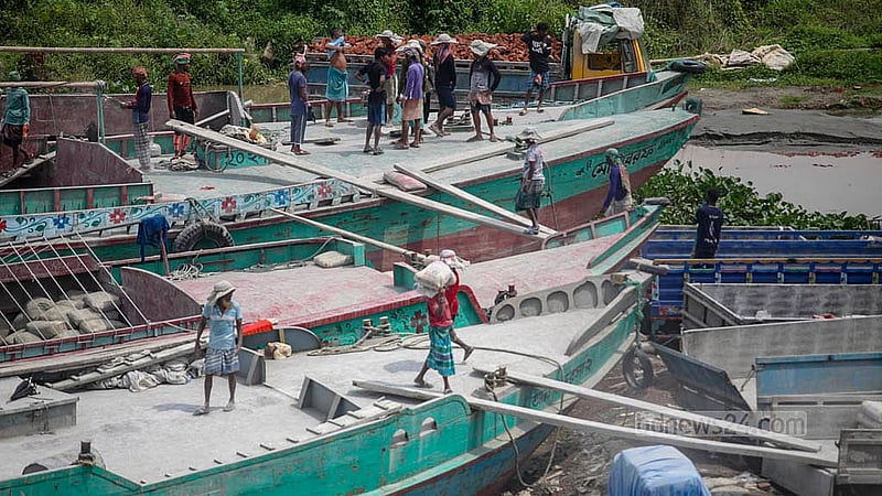 Workers unload cement from barges under Dhaleshwari Bridge No. 1 in Keraniganj. Photo: Abdullah Al Momin