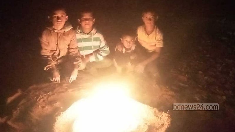 A group of four boys - (from left) Umor, Fahim, Noor, and Munna - gather around a fire to warm themselves up in Rangpur city on Monday, Jan 20, 2024.