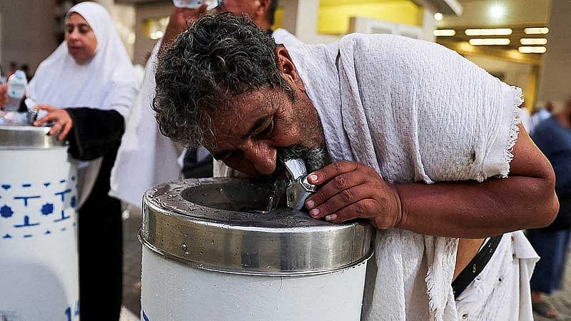 Muslim pilgrims drink water during extremely hot weather, on the first day of the Satan stoning ritual, during the annual haj pilgrimage, in Mina, Saudi Arabia, June 16, 2024. REUTERS/Saleh Salem 
