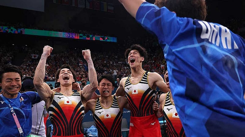 Paris 2024 Olympics - Artistic Gymnastics - Men's Team Final - Bercy Arena, Paris, France - July 29, 2024. Daiki Hashimoto, Takaaki Sugino and Wataru Tanigawa of Japan celebrate after winning gold. REUTERS/Amanda Perobelli
