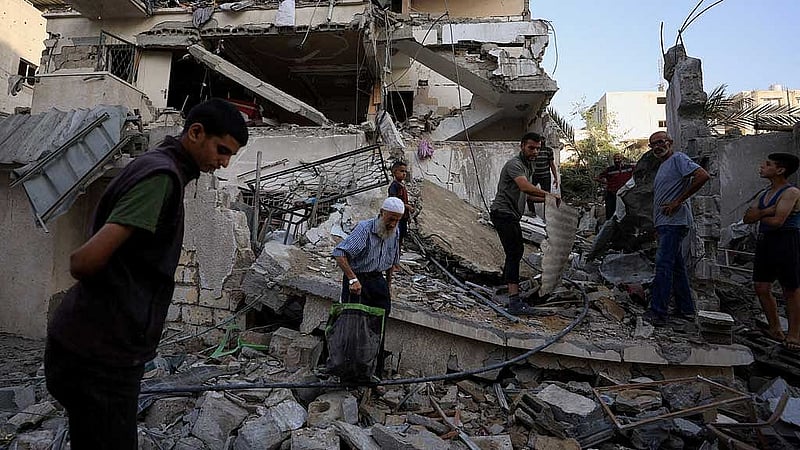 Palestinians inspect the site of an overnight Israeli strike on a house, in Gaza City, August 20, 2025. REUTERS