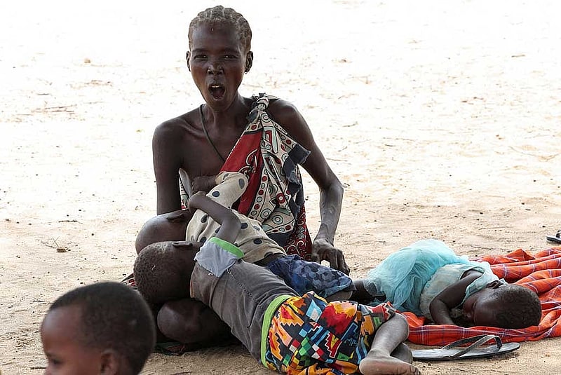 A Turkana woman waits with her child for malnutrition screening in Lomolem village, Turkana County, Kenya, Oct 29, 2025. REUTERS/Monicah Mwangi