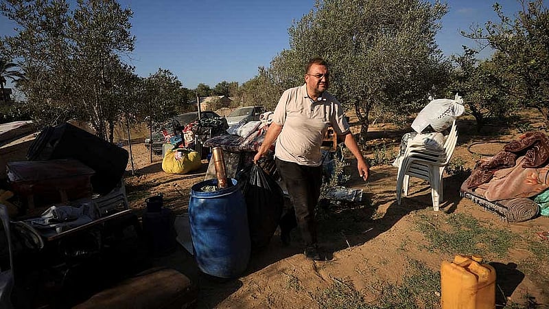 Palestinian Shady Salama Al-Rayyes, who fled his apartment in the 15-story Mushtaha Tower in Gaza City minutes before an Israeli strike hit the building, carries his belongings in Deir Al-Balah in the central Gaza Strip, September 18, 2025. REUTERS